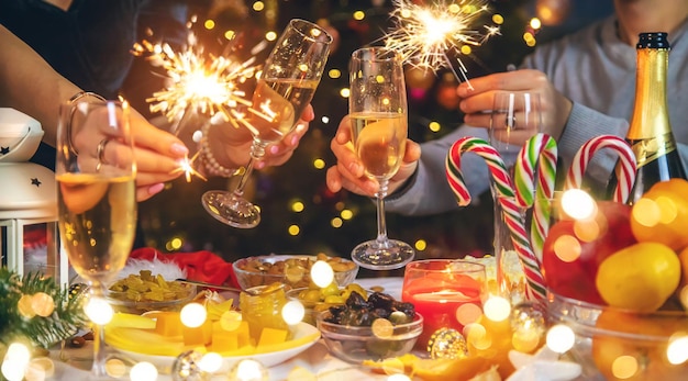 Champagne à la main sur fond de sapin de Noël. Gens. Mise au point sélective.