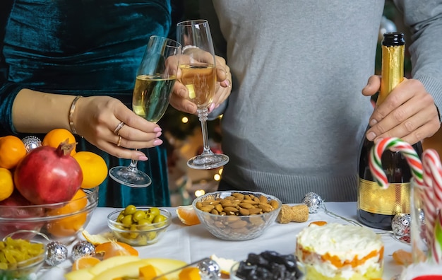 Champagne à la main sur fond de sapin de Noël. Personnes. Mise au point sélective. Vacance.