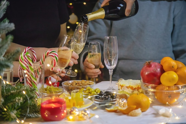 Champagne à la main sur fond de sapin de Noël. Personnes. Mise au point sélective. Vacance.