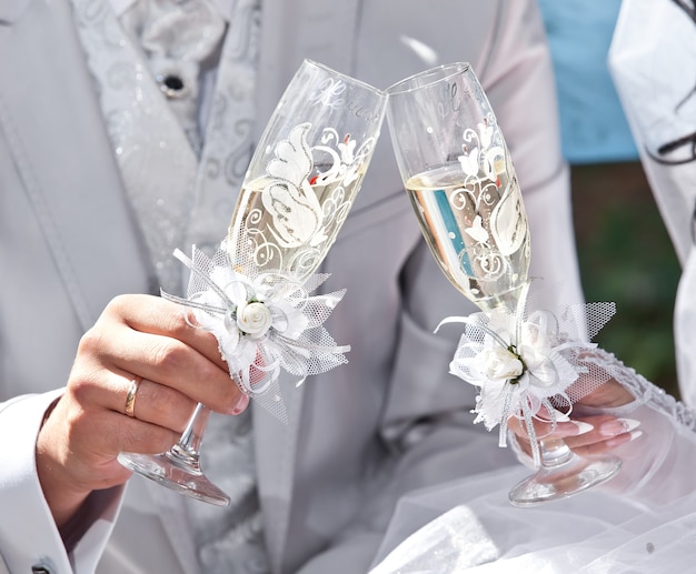 Champagne de mariage dans les mains des mariés