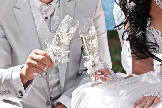 Champagne de mariage dans les mains des mariés