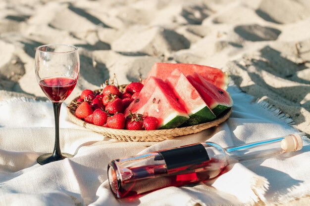 Champagne avec un plateau de fruits fraises et cerises en pique-nique