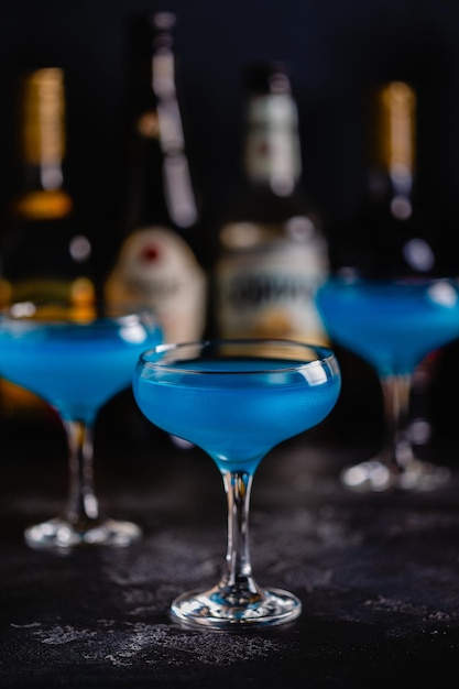 Champagne vin cocktail bleu sur une table sombre