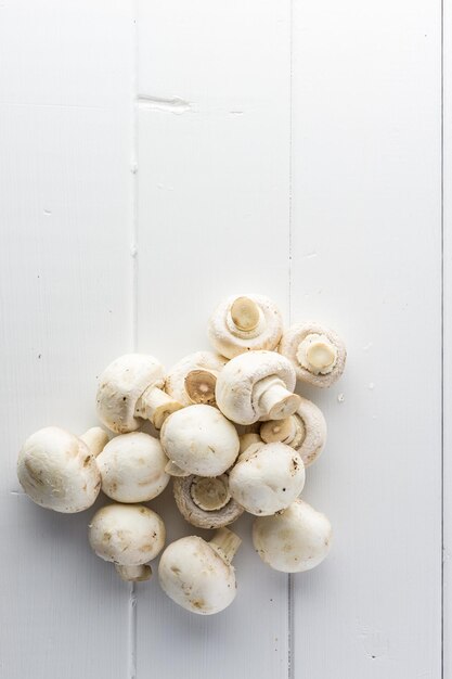 Champignon de champignons frais sur une planche de bois blanche