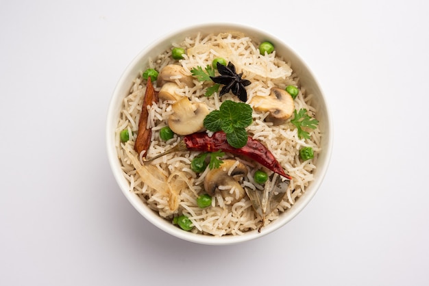 Champignon savoureux ou riz aux champignons ou Pulav ou Pilaf ou Pulao ou Biryani servi dans un bol ou une assiette, mise au point sélective