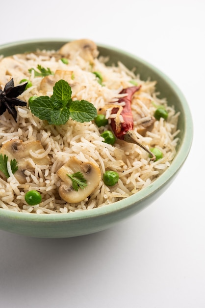 Champignon savoureux ou riz aux champignons ou Pulav ou Pilaf ou Pulao ou Biryani servi dans un bol ou une assiette, mise au point sélective