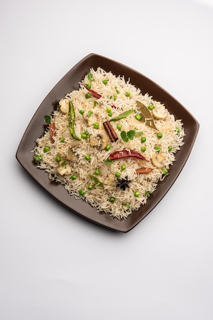 Champignon savoureux ou riz aux champignons ou Pulav ou Pilaf ou Pulao ou Biryani servi dans un bol ou une assiette, mise au point sélective