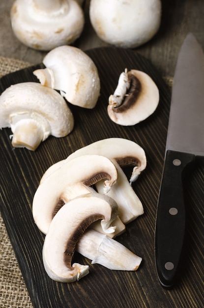 Champignons aux champignons sur une planche à découper en bois