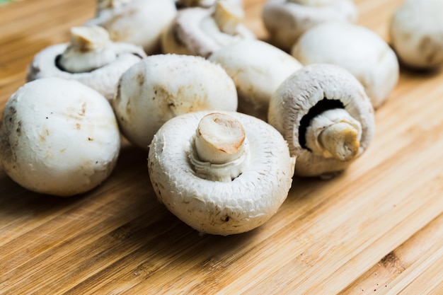 Champignons blancs sur planche de bois