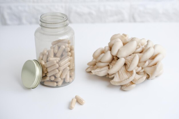 Photo champignons et une bouteille avec supplément de capsules de champignons sur une table supplément nutritionnel antioxydant et détoxifiant mise au point sélective des superaliments végétaliens