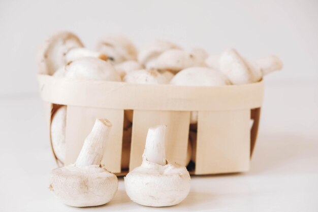 Champignons Champignon dans un panier en osier sur fond blanc