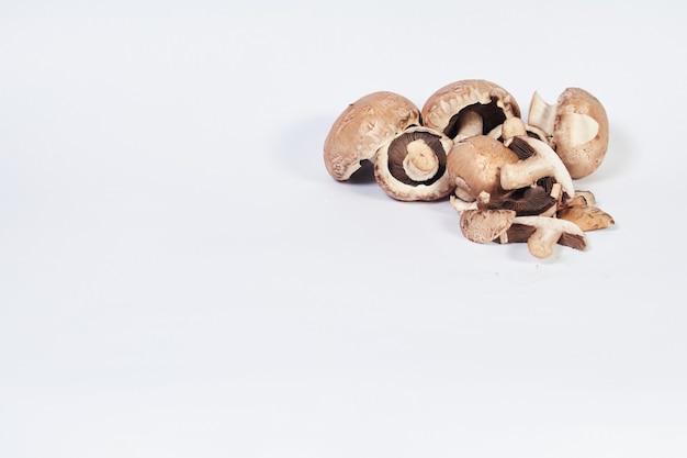 Champignons champignon, variété brune, dans le coin supérieur droit sur une surface blanche avec espace pour écrire.