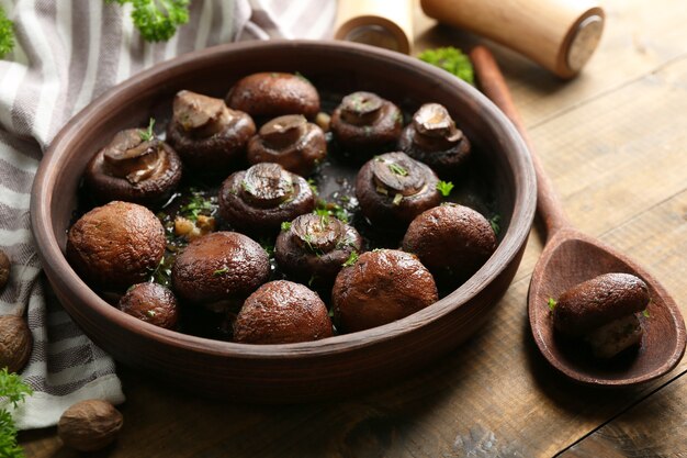 Champignons champignons cuits au four avec du beurre, du persil et de l'ail rôti dans un bol brun
