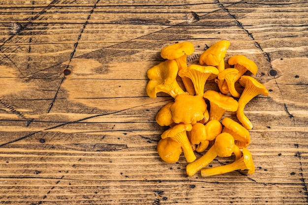 Champignons Chanterelles sauvages crus non cuits Fond en bois Vue de dessus Espace de copie