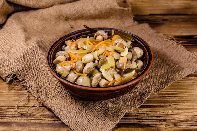 Champignons en conserve avec carotte et oignon dans un bol en céramique