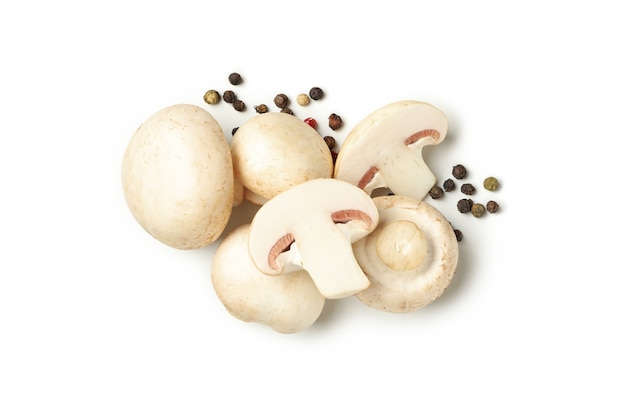 Champignons crus et grains de poivre isolés