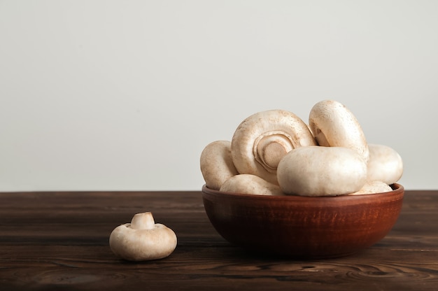 Champignons dans une assiette sur une planche de bois sombre