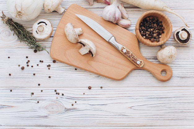 Champignons avec différents ingrédients blancs sur la table en bois, vue de dessus et poser à plat.