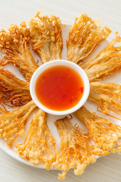 champignons enoki frits ou champignons à aiguilles dorées avec sauce épicée - style végétalien