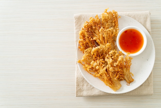 champignons enoki frits ou champignons à aiguilles dorées avec sauce épicée - style végétalien