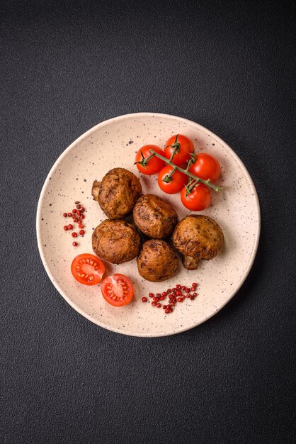 Photo des champignons entiers délicieux et juteux cuits au gril avec du sel et des épices.