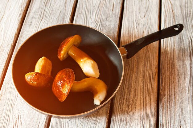 Champignons entiers sur poêle noire. Poêle aux champignons crus. Ingrédient pour repas végétarien. A meilleur goût en ragoût.