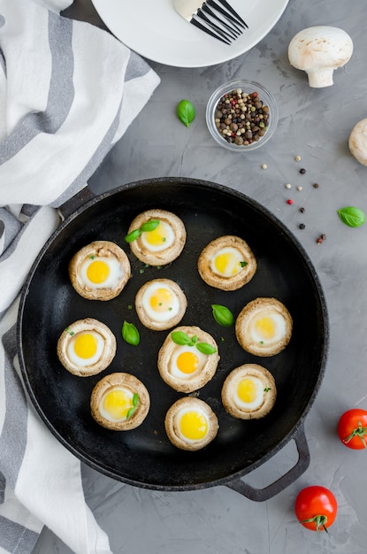 Champignons farcis au four avec des œufs de caille avec des feuilles de thym et du basilin