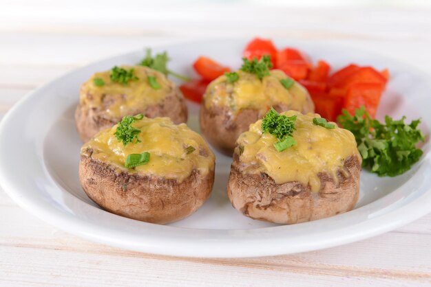 Champignons farcis sur plaque sur table sur fond clair