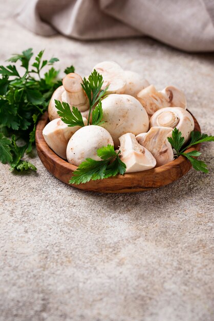 Champignons frais crus dans un bol en bois