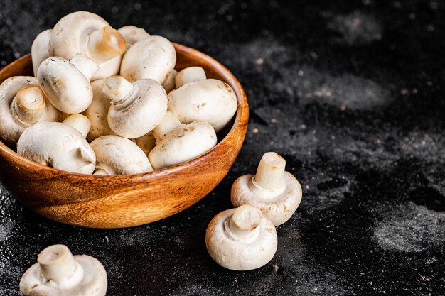 Champignons frais dans une assiette en bois