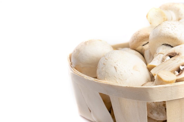 Champignons frais dans un panier isolé sur fond blanc