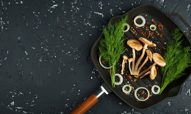 Champignons frais avec des épices et des herbes sur tableau noir. Vue d'en-haut. Espace de copie.