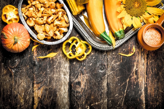 Champignons frais avec des légumes sur un fond en bois