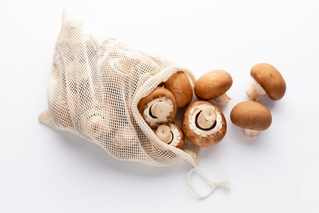 Champignons frais sacs en coton écologique sur fond blanc.