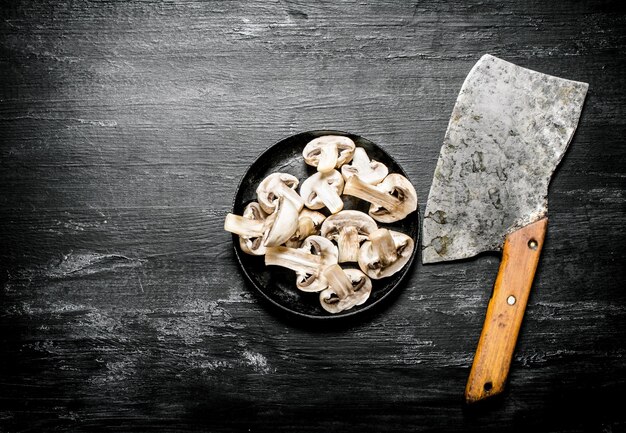 Champignons frais tranchés avec la hachette.