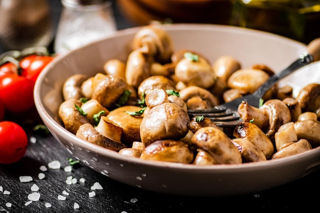 Photo champignons frits dans un bol avec tomates cerises