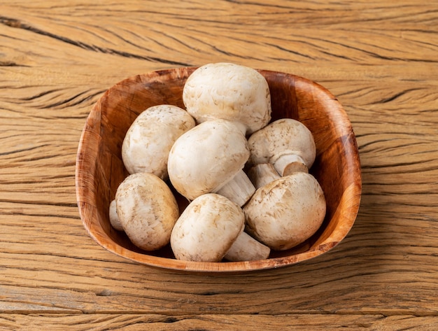 Champignons de Paris dans un bol sur une table en bois