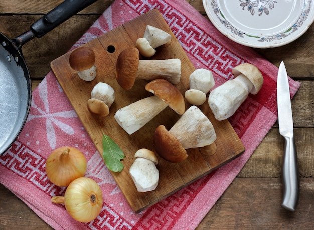 Champignons sur une planche à découper, vue de dessus. Nature morte aux cèpes.