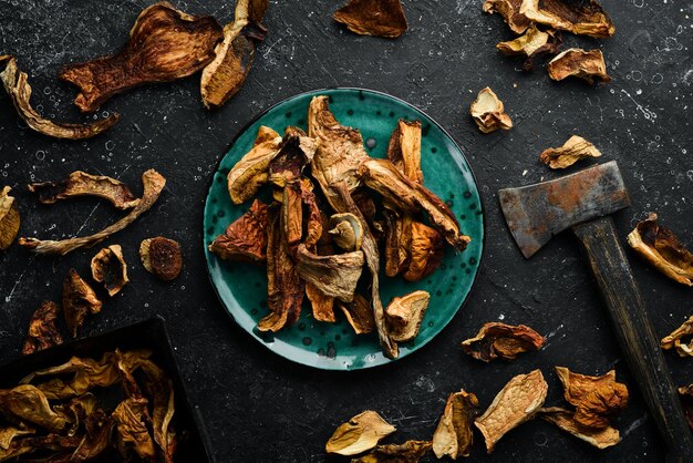 Champignons porcini biologiques sauvages séchés sur fond de pierre noire Nourriture d'automne Vue de dessus Espace libre pour le texte