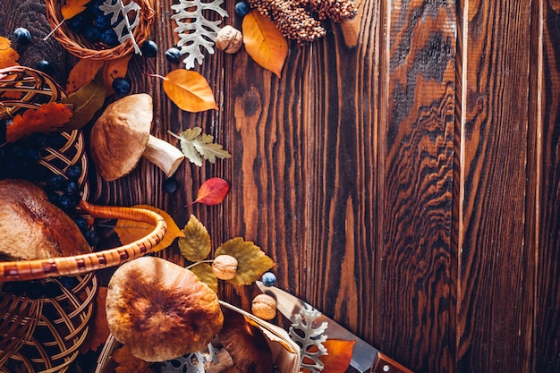 Champignons Porcini dans le panier avec des baies et des noix sur une table en bois. Récolte d'automne. Récolte d'automne cueillie.