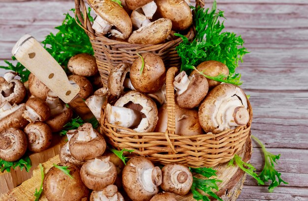 Champignons portobello bruns dans un panier en bois en osier avec décoration d'herbe.