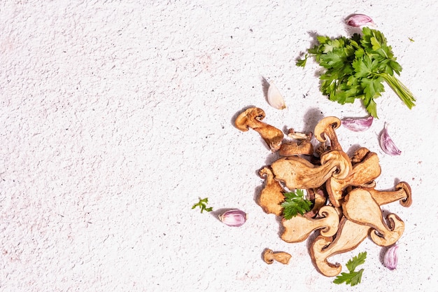 Champignons séchés Boletus edulis (Penny bun, Cep, Porcini) sur fond de plâtre texturé. Ingrédient pour une alimentation saine végétarienne (végétalienne). Une lumière dure à la mode, une ombre sombre, une vue de dessus