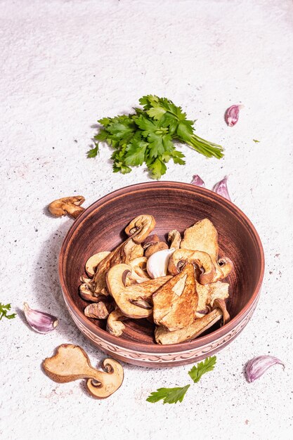 Champignons séchés Boletus edulis (Penny bun, Cep, Porcini) sur fond de plâtre texturé. Ingrédient pour une alimentation saine végétarienne (végétalienne). Une lumière dure à la mode, une ombre sombre