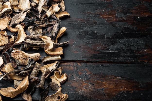 Champignons séchés sauvages de cèpes, sur fond de table en bois foncé ancien, avec un espace pour le texte