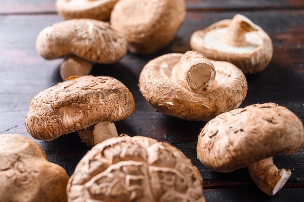 Champignons shiitake posés sur une vieille table en bois, vue latérale mise au point sélective.