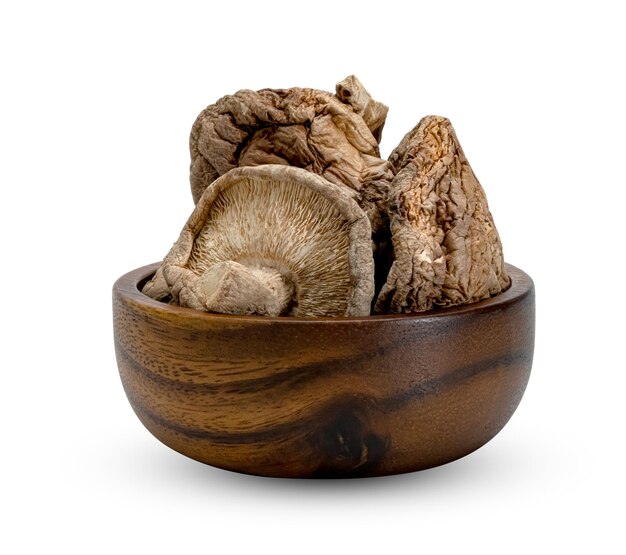 champignons shiitake secs dans un bol en bois isolé sur fond blanc