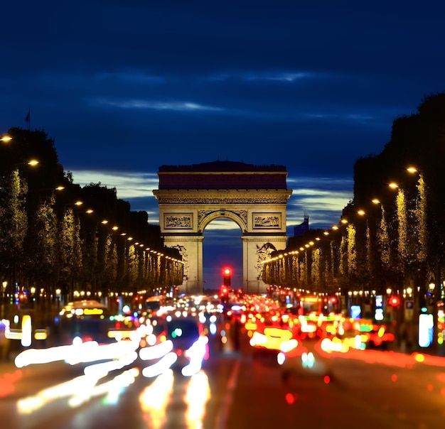 Photo champs elysée illuminé et vue sur l'arc de triomphe en soirée parisienne, france