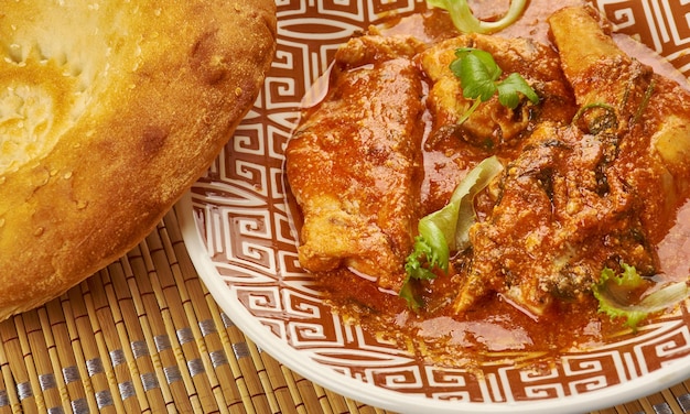 Chana Aur Khatte Pyaaz Ka Murgh - Morceaux de poulet indiens cuits avec des échalotes marinées et une sauce aux pois chiches, servis avec de la parantha
