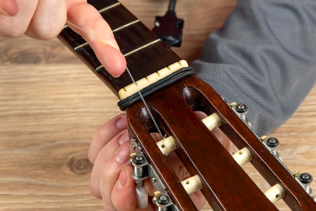 Changement de cordes en nylon sur une guitare classique à six cordes. instruction pour musicien