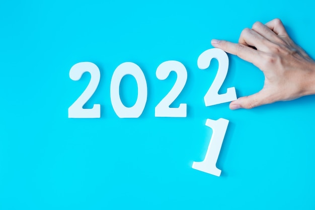 Changement de main numéro 2021 à 2022 sur fond bleu. Plan, finance, résolution, stratégie, solution, objectif, affaires et concepts de vacances du Nouvel An